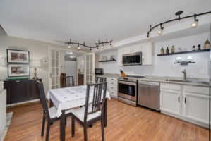 The kitchen features newer appliances purchased in 2020, contemporary track lighting and lovely granite counter tops.